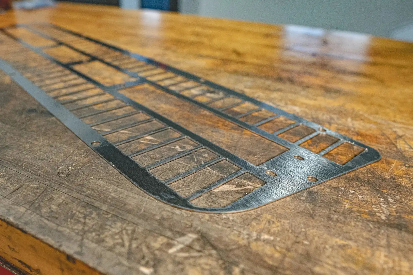 Angled view of a metal grate on a workbench.