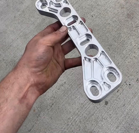 Person holding a machined metal part.