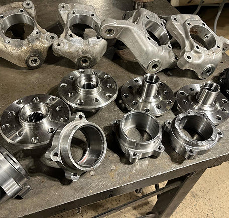 Assorted metal hub components on a workshop table.